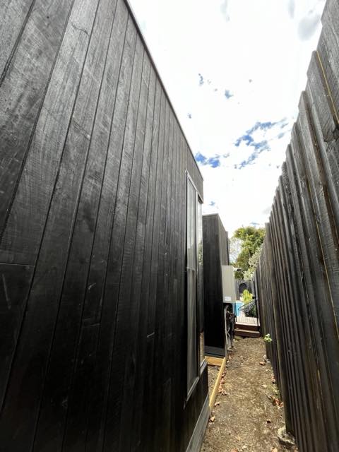 Black vertical timber cladding along a side passage