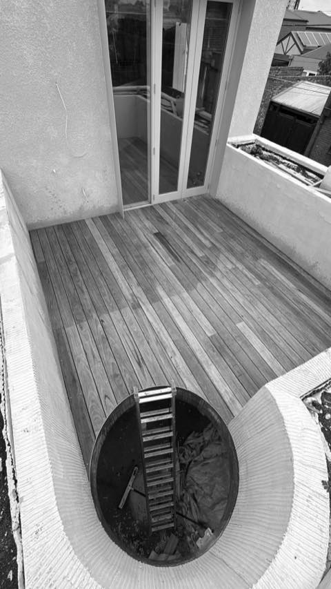 Black-and-white view of a hardwood balcony deck outside glazed doors